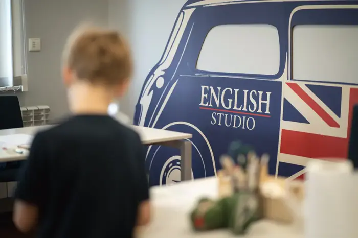Chłopiec przy muralu z logo English Studio