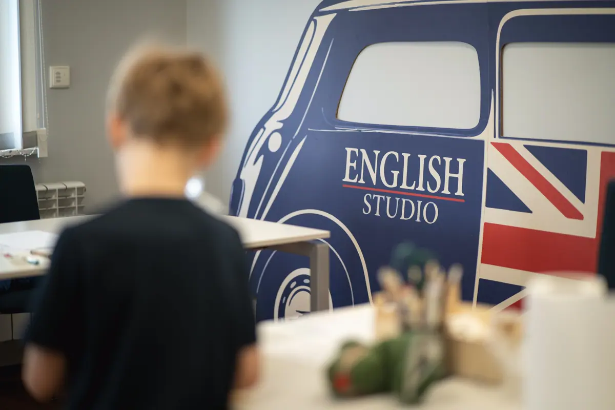 Chłopiec przy muralu z logo English Studio
